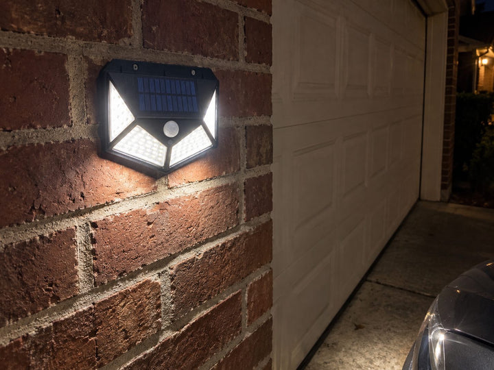 Solar light mounted on brick beside a garage door