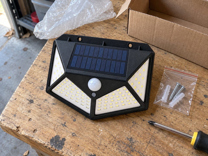 Solar light with mounting screws and anchors on a workbench